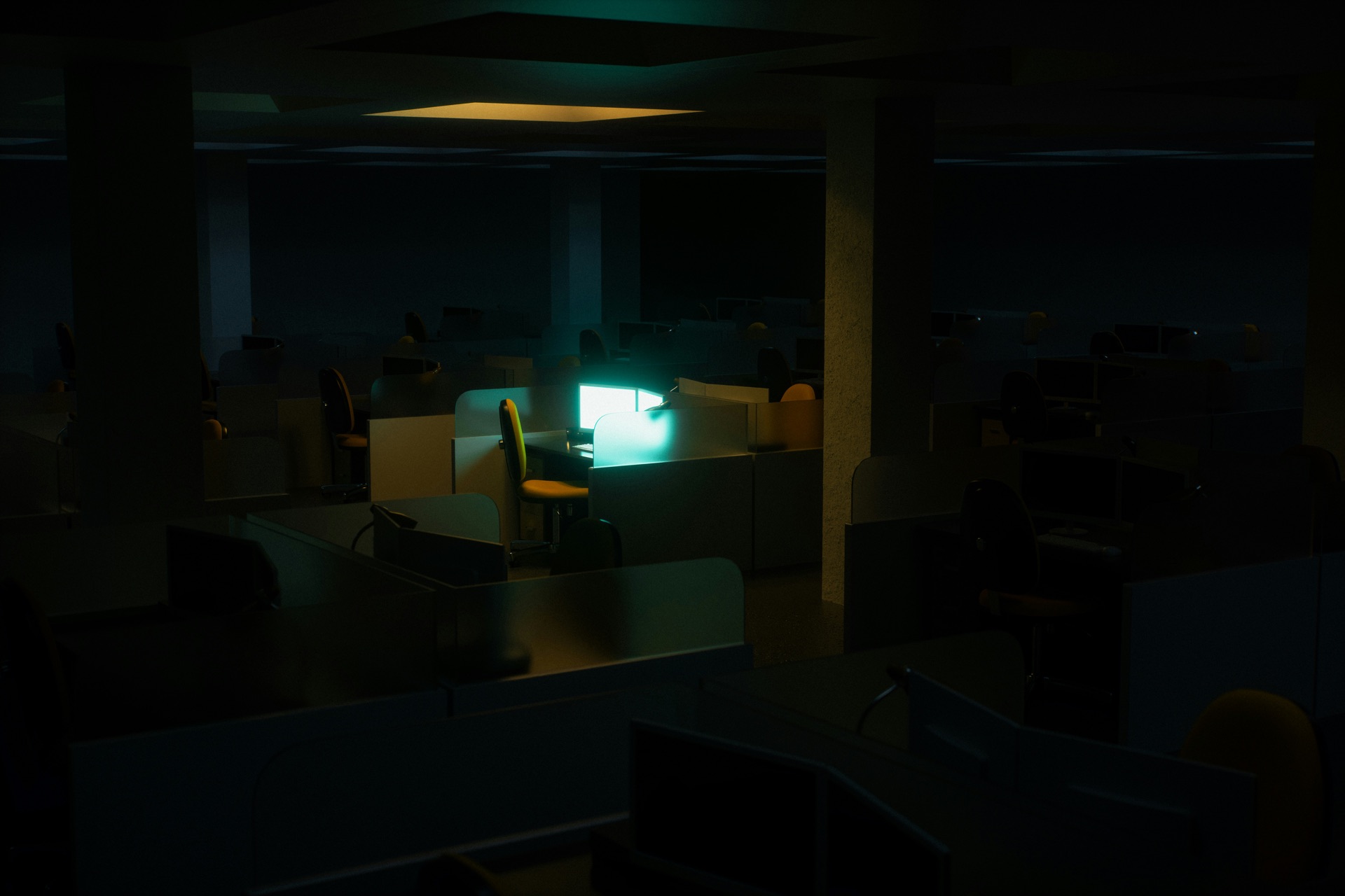 Dimly lit office workspace with a glowing monitor.